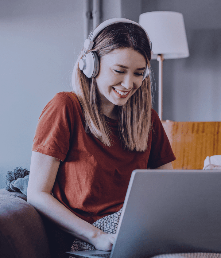 Person on their laptop and wearing headphones.